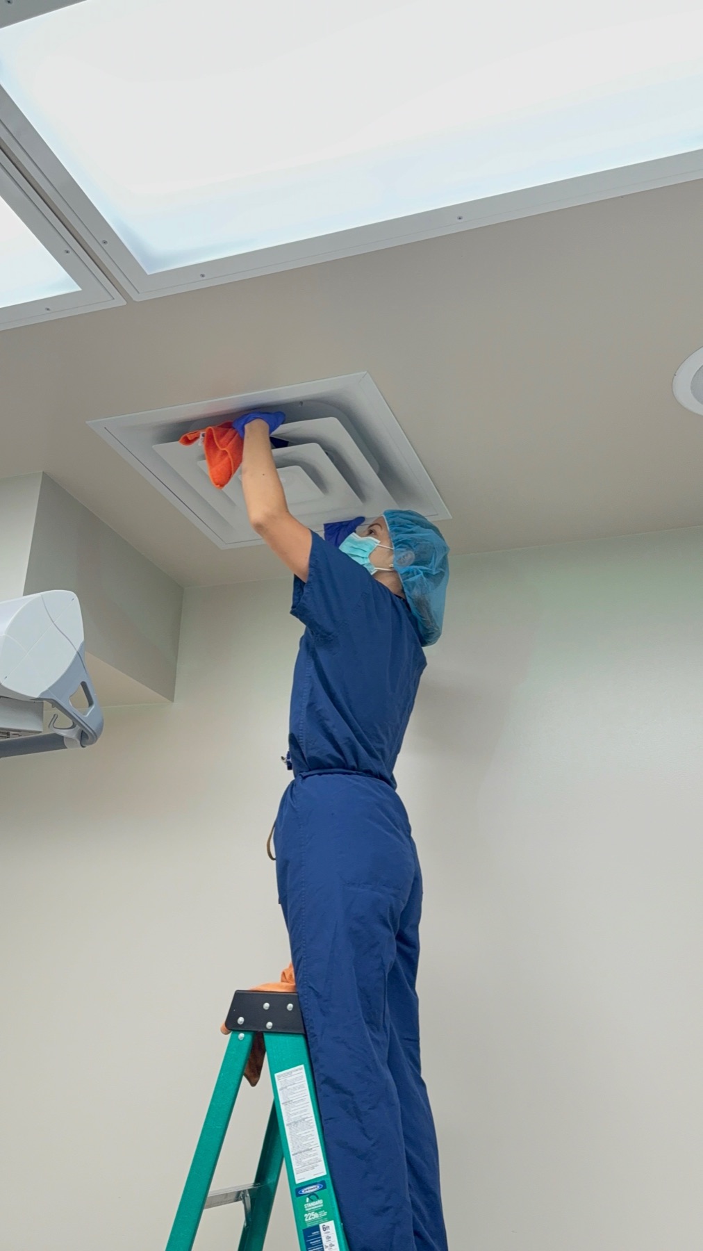 Wiping a ceiling diffuser by hand