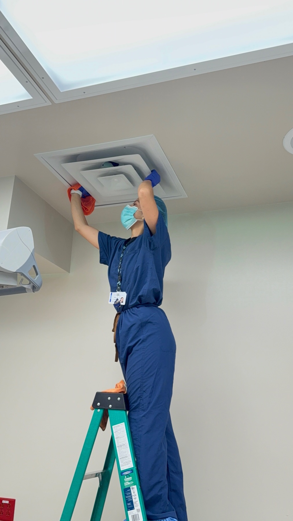 Ceiling diffuser detail work on a ladder
