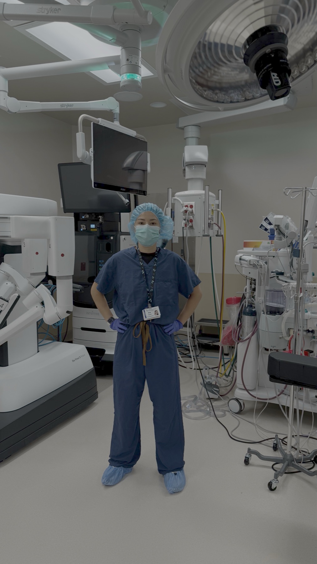 Technician in scrubs beside surgical equipment